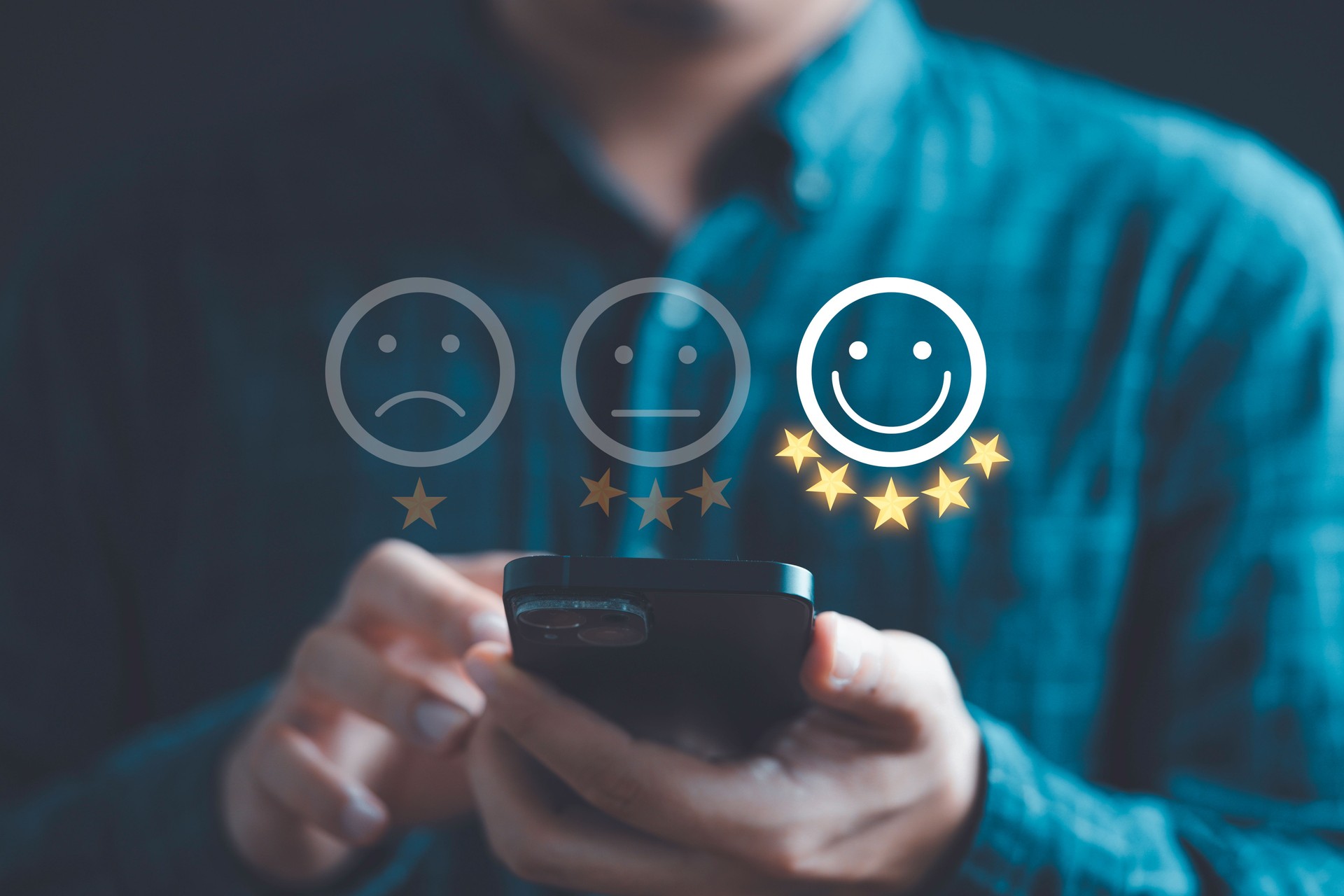 Businessman using smartphone to give five glowing golden stars and smile face icon for excellent evaluation survey after client use product and service from customer satisfaction concept.